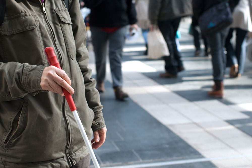 Stock image: A person walking with a white cane