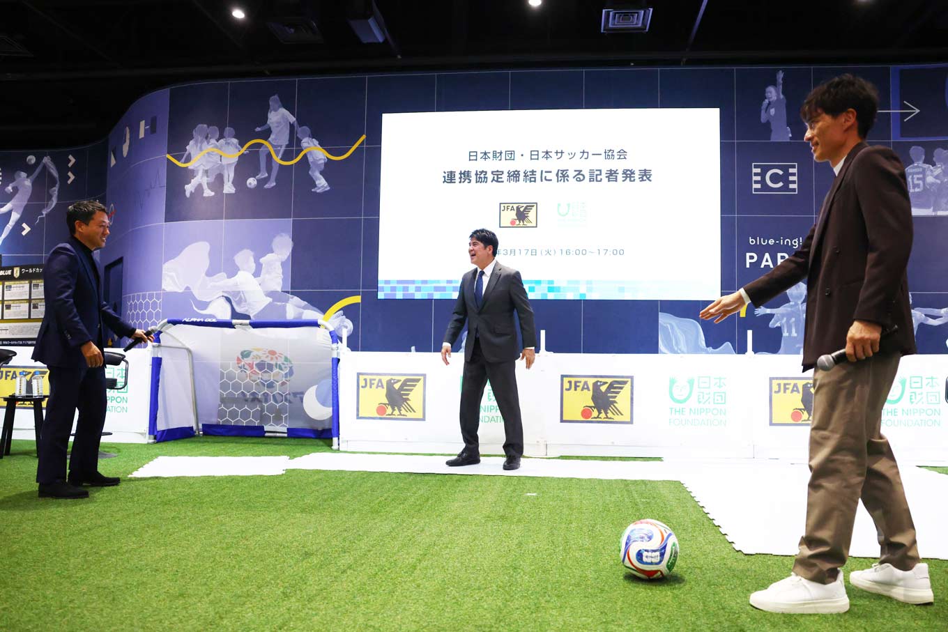 Photo of a soccer ball being passed on an artificial turf playing surface（Photo credit: ©JFA）