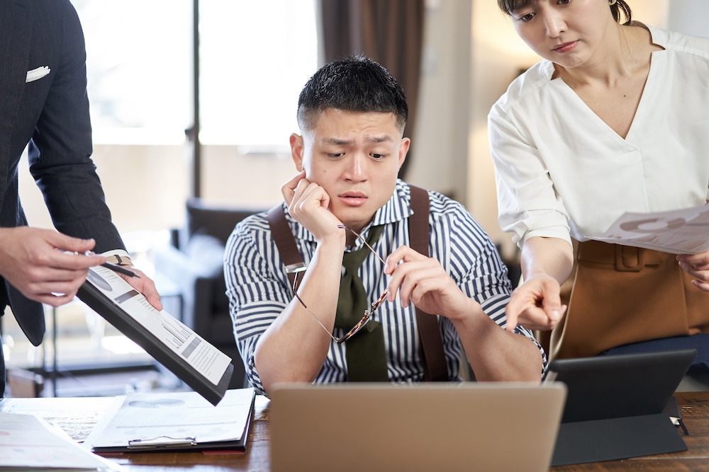 Photo (image): Man under pressure from colleagues at work giving him instructions