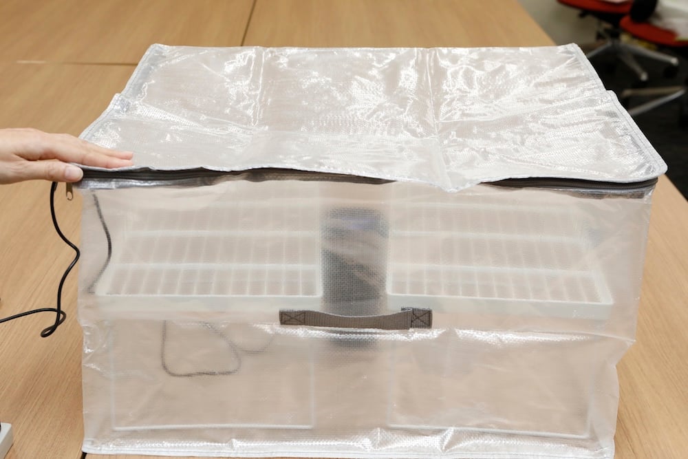 Inside a clear, zippered, foldable storage case are a car-use nanoe™ generator and two folding stackable shelves. This is the Anything Bag.