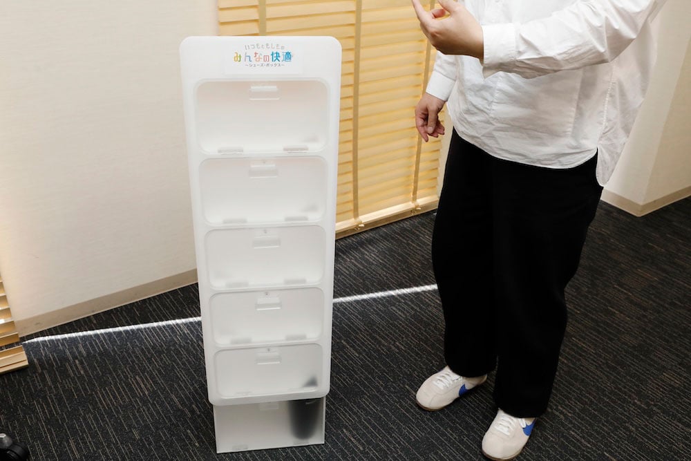 A white, upright shoe cabinet, about waist height.