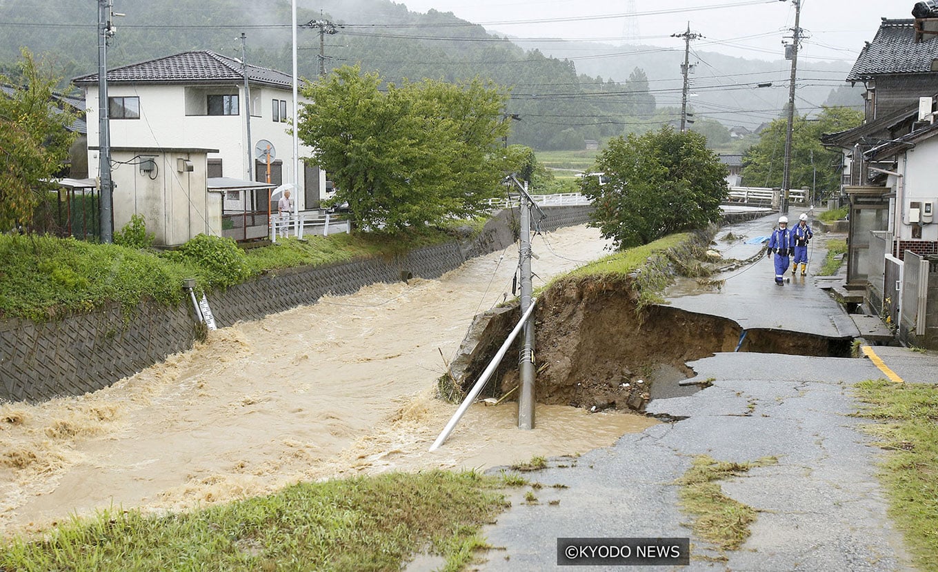 Photo of a washed-out residential street next to a raging river