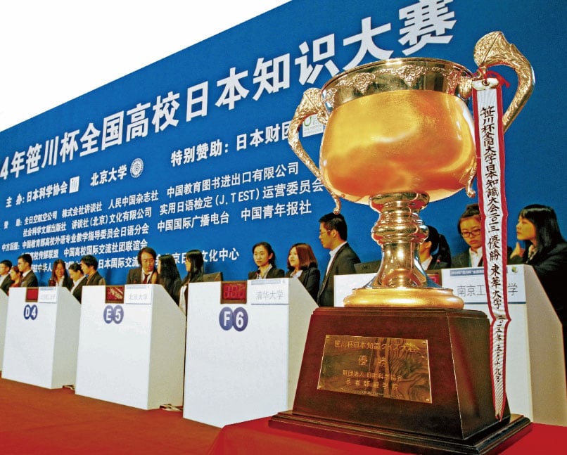 Photo of participants on stage with the trophy cup in the foreground