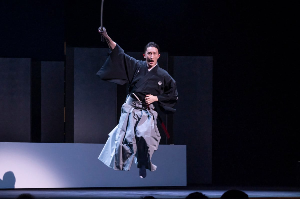 Photo of a performer dancing while holding a sword