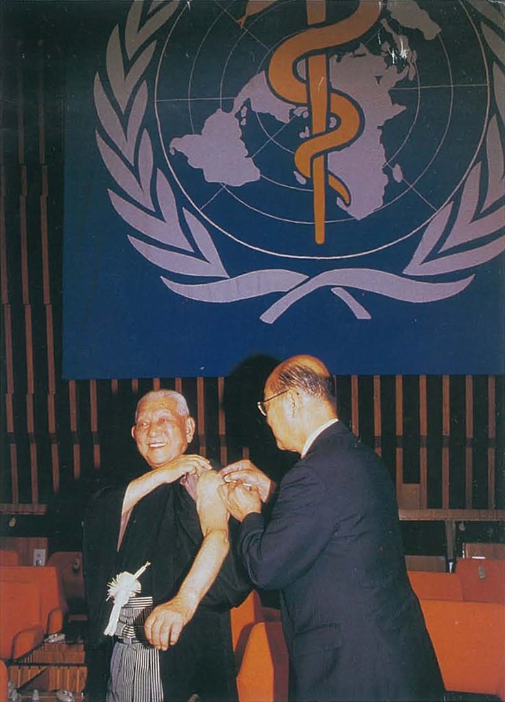 Photo of a local health worker examining children in rural Africa