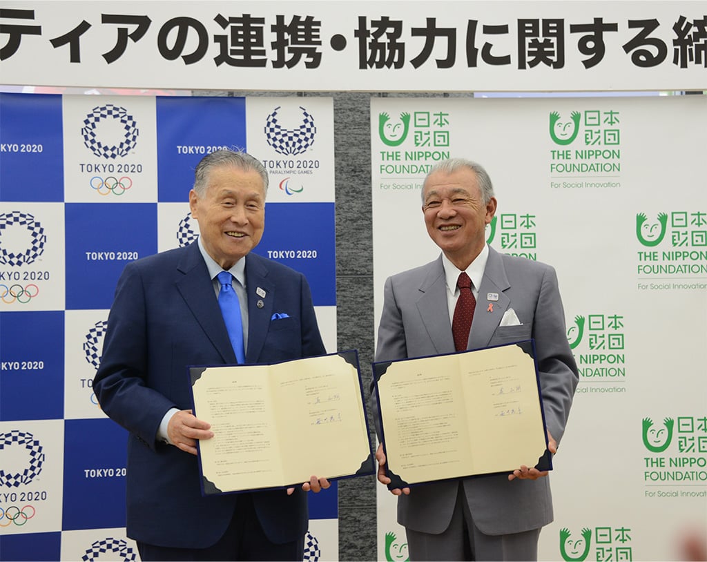 Photo of Tokyo 2020 President Yoshiro Mori (left) and The Nippon Foundation Chairman Yohei Sasakawa (right) with the signed agreements for volunteer partnership